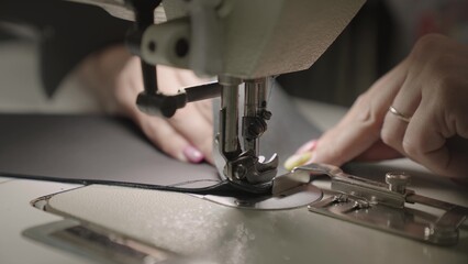 Partnov hands are sewing from leather sewing machine. close-up. small business concept. work...