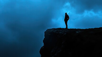 Silhouette on cliff, stormy blue sky, solitude.