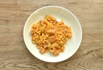 baking macaroni and slice ham pork sausage with cheese on plate