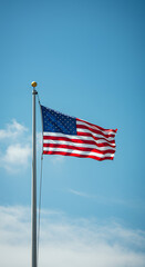 Obraz premium American Flag Waving Proudly: Stars, Stripes, and Patriotic Symbolism Against a Bright Blue Sky. United States Pride!