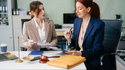 Obraz premium Professional female lawyers consulting on legal cases in a modern office. Perfect for law, business, justice