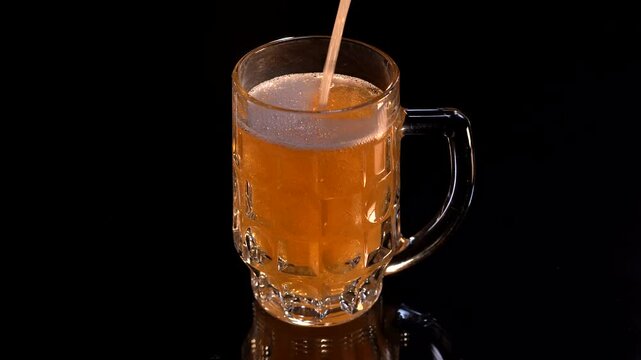 Glass filled with wheat beer, foamy bubbles on top, isolated on black background. - Close-up, studio shot.