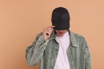 Man in stylish baseball cap on beige background. Mockup for design