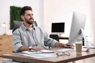 Naklejka premium Man working on computer at table in office