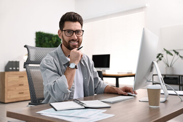 Fototapeta premium Man working on computer at table in office