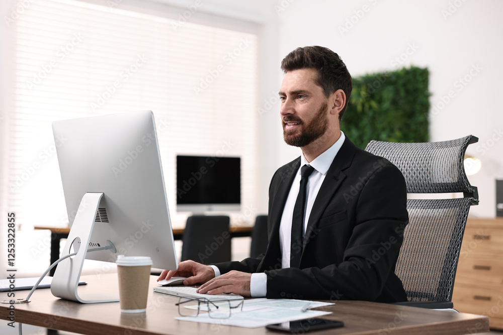 Poster man working on computer at table in office