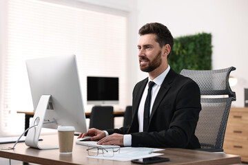 Man working on computer at table in office