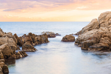 Paisaje marino al atardecer en una cala rocosa
