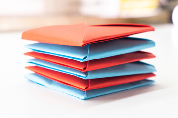Square envelope made of red and blue paper. Origami envelope on white background