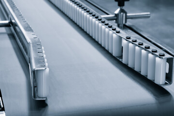 Fragment of the conveyor of sticking labeling machine. Abstract industrial background.