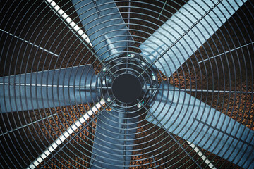 Industrial Fan with dust center and sih blades. The fan is silver and the center is black.