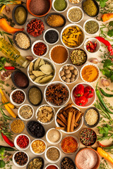 Assorted spices and herbs on a beige background, offering rich scents and vibrant colors, ideal for adding depth and warmth to any culinary creation