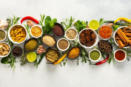 A collection of various spices and herbs on a gray background, perfect for enhancing dishes with rich flavors and textures