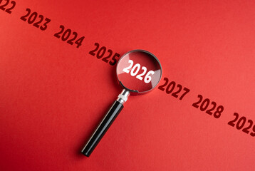 The year 2026 on the year scale in the focus of a magnifying glass. Upcoming trends. Financial...
