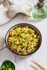 A bowl of instant noodles and vegetables on the table vertical view