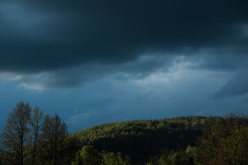 black sky before a thunderstorm rain tree in the mountains