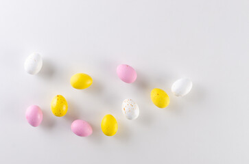 Happy Easter concept! Colorful Easter chocolate eggs on white. Easter greeting card, spring template.