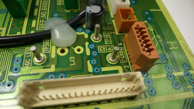 Focus on a Microchip, CPU Processor. Printed Circuit Board Computer Motherboard with Components: Inside of Electronic Device. Neon Colors. Cyber Security Safety Concept. Rotating Macro Shot