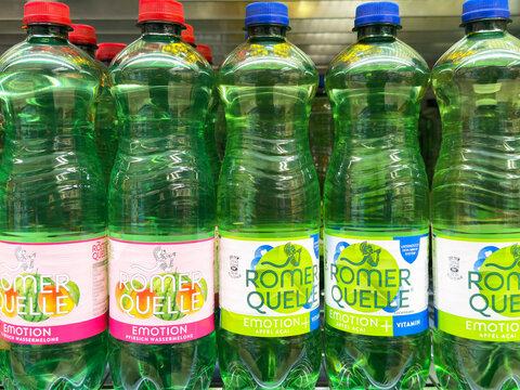 Various flavors of romer quelle mineral water bottles on display shelf