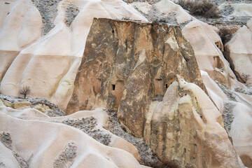 Cappadocia in winter: ancient stone dwellings carved into natural volcanic rocks in the Cappadocian landscape, Turkey.