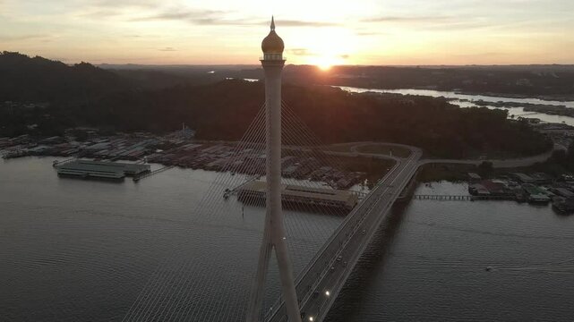 Breathtaking aerial drone footage circling around the top dome of RIPAS Bridge in Brunei, showcasing its stunning architecture and scenic river views.