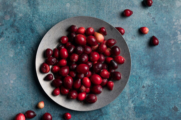 Overhead of a plate of cranberries and a pot full of whole cranberry