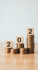 2022 Savings Growth: Coins & Wooden Blocks Stacked High! Finance, Investment, & Future Success Concept