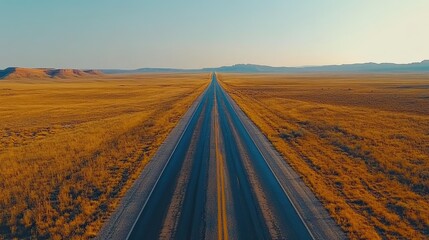 Aerial view of an empty stretch of road leading into the horizon, symbolizing freedom, travel, and the allure of open roads for adventure, road trips, and the spirit of exploration.