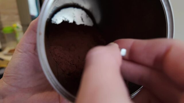 An indepth and detailed look at the rich coffee powder carefully stored inside a shiny stainless steel container