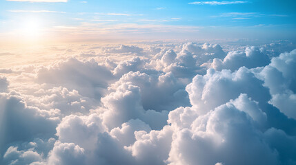 A serene aerial view of fluffy white clouds under a bright blue sky, illuminated by the warm glow of the setting sun, creating a tranquil and uplifting atmosphere.