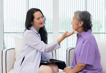 Obraz premium cosmetic surgeon,one hand holding tablet,other hand touching senior woman face to check her facial skin condition for treatment at aesthetic clinic