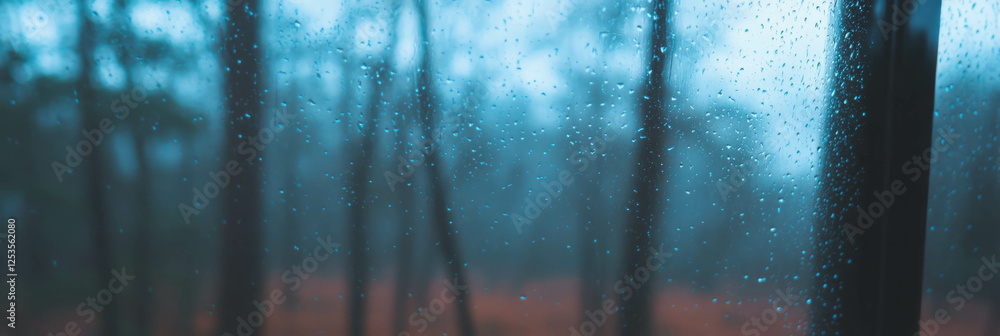 Poster blurred view of a forest through rain-streaked glass with soft bokeh effects