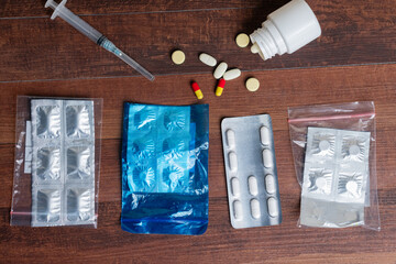 Variety of Medications and Syringe on Wooden Surface
