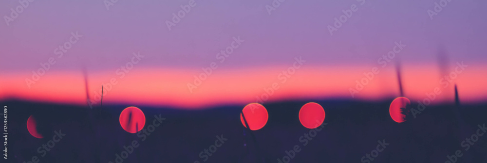 Aufkleber sunset over a field with vibrant bokeh circles blending into purple hues