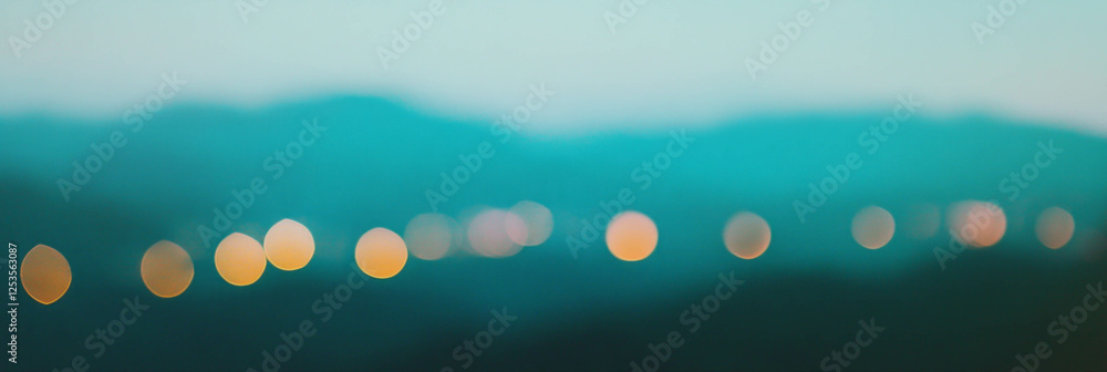 Poster blurred mountain landscape with distant bokeh lights creating a bright background ambiance