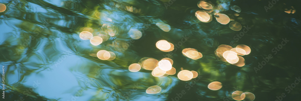 Poster blurred water surface reflecting trees with varied bokeh circles in a bright backdrop