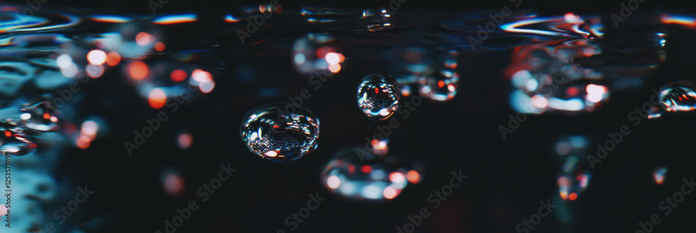 Aufkleber droplets on dark surface creating stunning reflections and highlights with bright background
