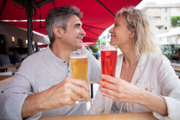 happy mature couple toasting each at an outdoor table