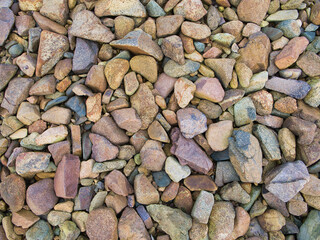 A closeup of colourful, weathered stones on a beach.