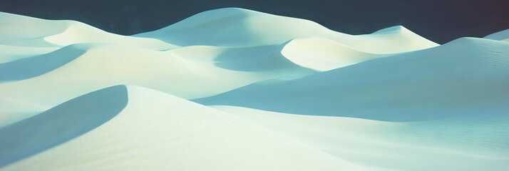 Endless snow dunes display geometric patterns under bright sunlight