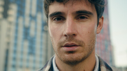 Close up man Caucasian unhappy worried alone guy sad face expression headshot outdoors pensive...