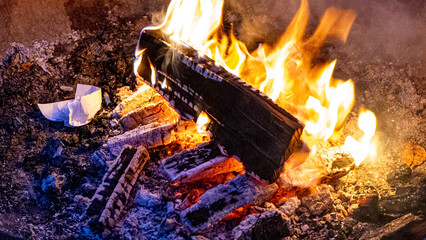 warm camp fire - close up with blue glowing wood and brightly glowing flame and tissue on fire