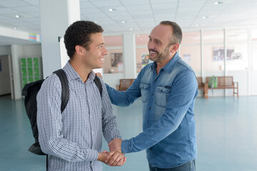 student shaking hands with a teacher