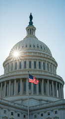 Obraz premium U.S. Capitol Building: A Beacon of Democracy - American Flag, Sunlight, and Architectural Grandeur in Washington D.C.