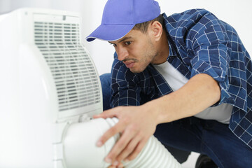 handyman assembling an air conditioning unit