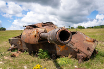 Old destroyed Russian tank on a grassy field