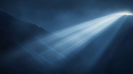 Obraz premium Dramatic beams of light piercing through misty mountain peaks in a dark atmospheric setting ethereal and mysterious with deep blue hues 