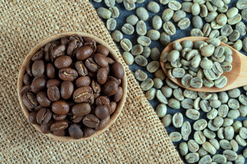 Green coffee with roasted coffee beans on burlap sack