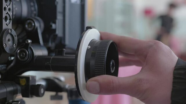 Adjusting camera lens with focus puller