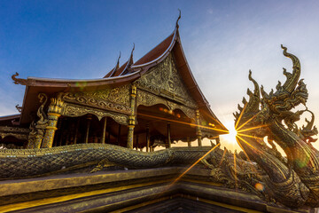 Fototapeta premium Background of the tourist attraction Wat Sirindhorn Wararam or the famous glowing temple in Thailand. Ubon Ratchathani is adjacent to Laos. Tourists always like to come to see the beauty at night.